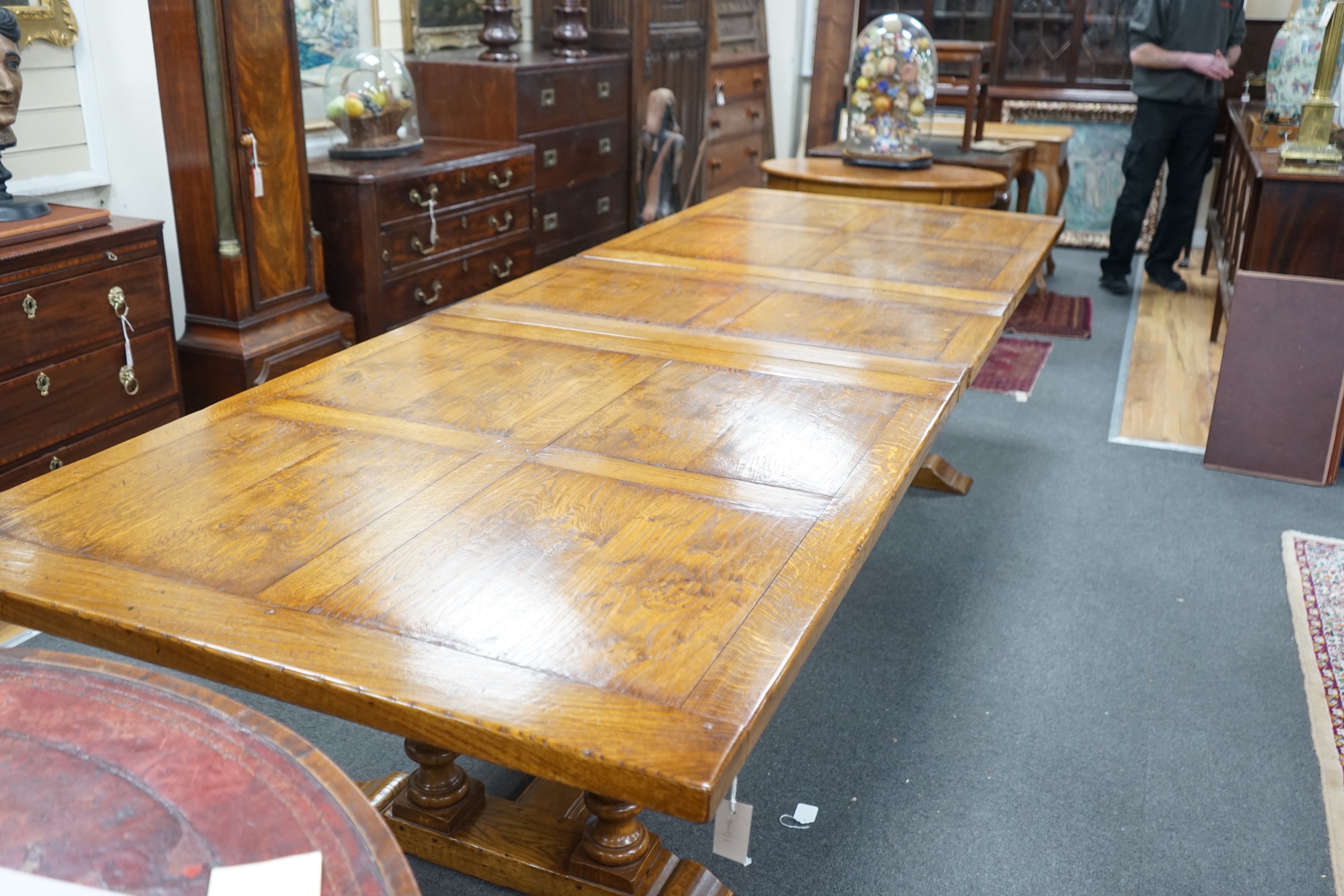 A reproduction 18th century style oak extending refectory dining table, length 306cm extended, one spare leaf, width 106cm, height 75cm